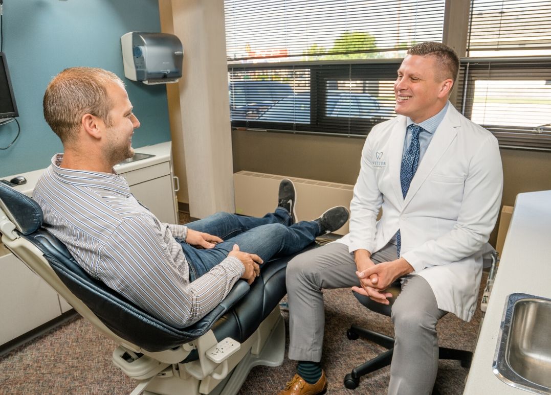 man sitting in chair talking to dentist digital dental impressions fargo
